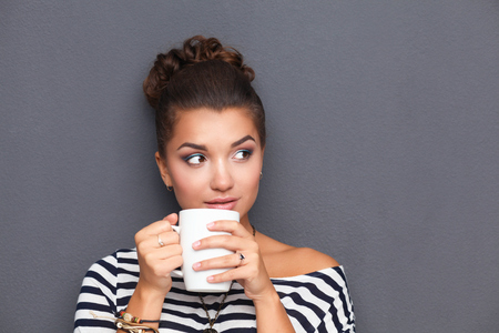 Portrait of young woman with cup tea or coffeeの写真素材