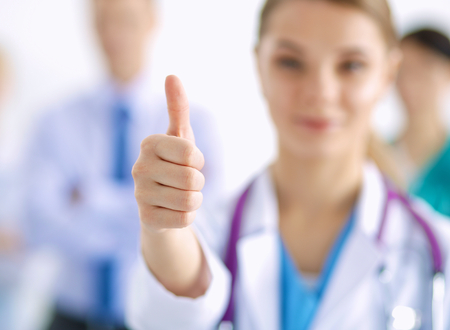 Woman doctor standing with stethoscope at hospitalの写真素材