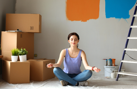 Woman in a new home with cardboard boxesの写真素材