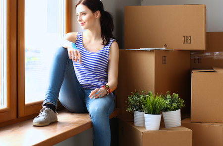 Girl sitting on windowsill at new homeの写真素材