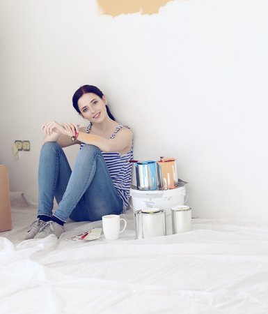 Young woman portrait while painting new apartmentの写真素材