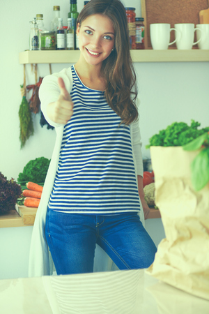 Young woman holding grocery shopping bag with vegetablesの写真素材