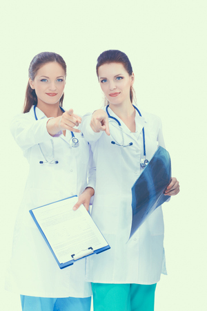 Two woman nurse watching X Ray image, standing in hospital, pointing youの写真素材