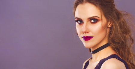 Close up portrait of beautiful young woman face. Isolated on gray background.の写真素材