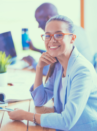 Business woman sitting in her office using a tablet computerの写真素材