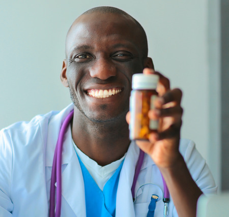 Close-up of male doctor giving jar of pills to patient.の写真素材