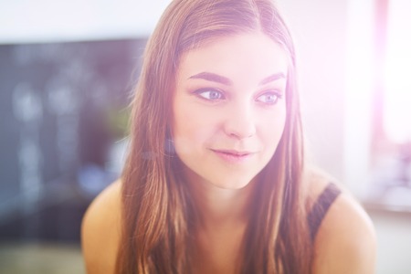 Beautiful woman cooking cake in kitchen standing near deskの写真素材