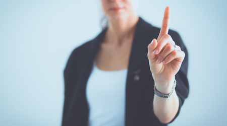 Woman touching an imaginary screen with her fingerの写真素材