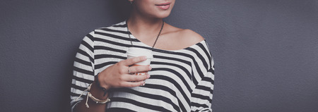 Portrait of a young woman with cup of tea or coffee.の写真素材