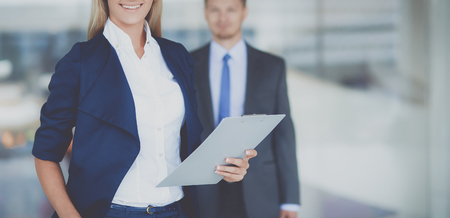 Portrait of young businesswoman in office with colleagues in the backgroundの写真素材