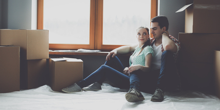 Couple moving in house sitting on the floorの写真素材