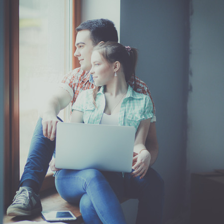 Couple moving in house sitting on the windowsillの写真素材