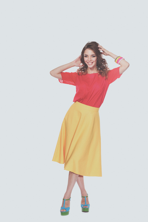 Beautiful woman with curly hair wearing a red jacket, isolated on white backgroundの写真素材