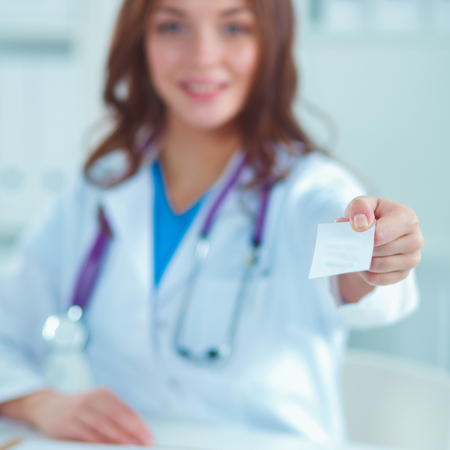 Female doctor holding an empty card, isolated on white backgroundの写真素材
