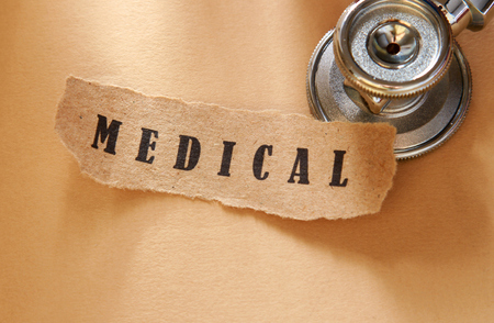 Word medical written on a ripped piece of paper and astethoscopeの写真素材