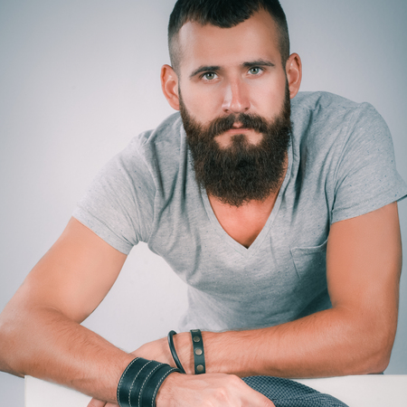 Portrait of young man in hat standing near blank, isolated on white backgroundの写真素材