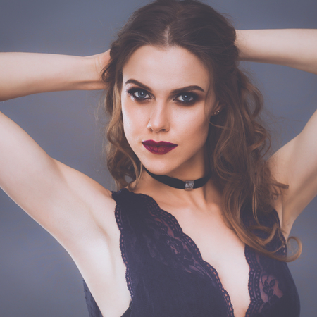 Close up portrait of beautiful young woman face. Isolated on gray background.の写真素材