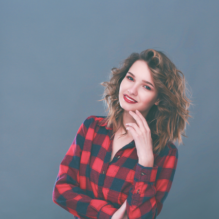 Young woman standing, isolated on gray background.の写真素材