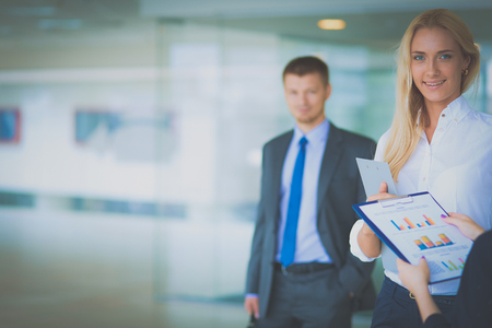 Portrait of young businesswoman in office with colleagues in the backgroundの写真素材