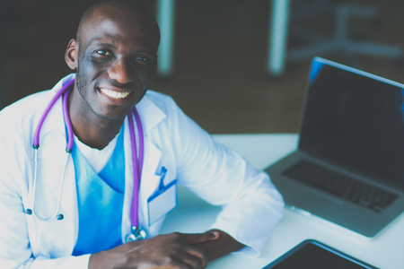 Young african doctor working on laptop at deskの写真素材