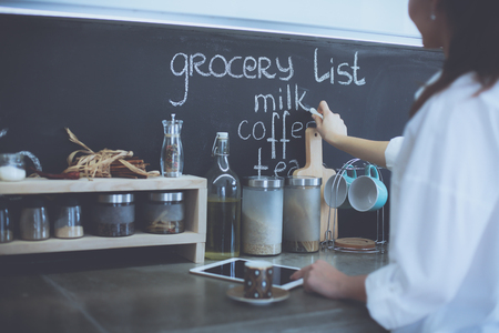 Young woman using a tablet computer to cook in her kitchenの写真素材