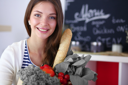 Young woman holding grocery shopping bag with vegetablesの写真素材