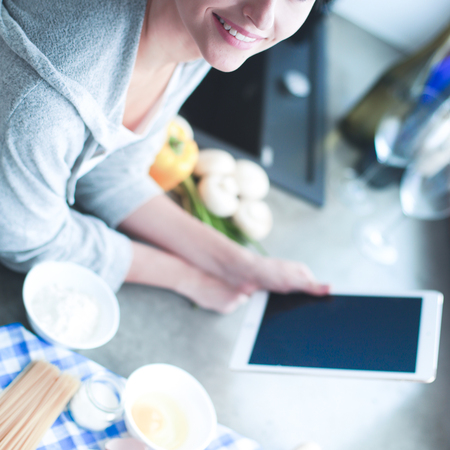 Woman baking at home following recipe on a tabletの写真素材