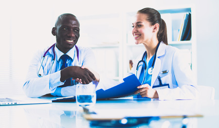 Two happy smiling young medical people handshaking at officeの写真素材