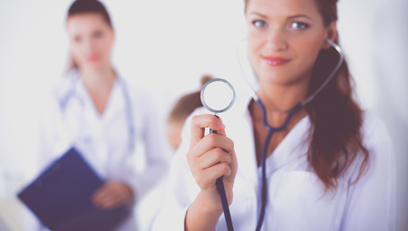 Woman doctor with folder standing at hospitalの写真素材