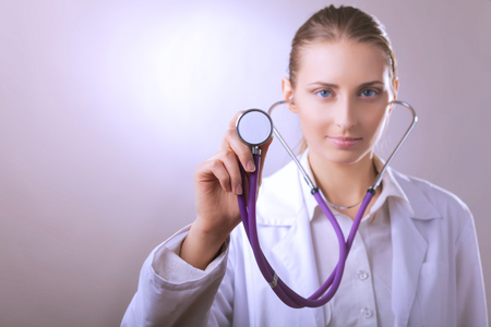 A young female doctor listening ,holding medical stethoscopeの写真素材