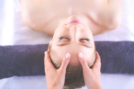 Young woman lying on a massage table,relaxing with eyes closedの写真素材