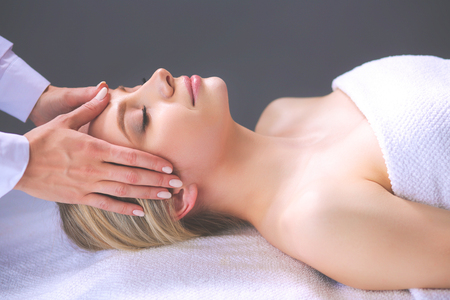Young woman lying on a massage table,relaxing with eyes closedの写真素材