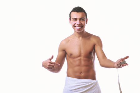 Young muscular man wrapped in a white towel isolated on white backgroundの写真素材