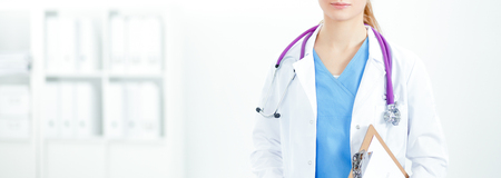Woman doctor standing with folder at hospitalの写真素材