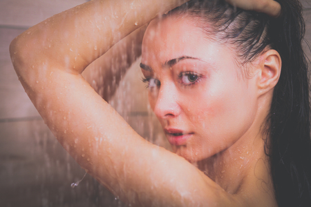 Young beautyful woman under shower in bathroomの写真素材