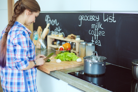 Young woman standing by the stove in the kitchenの写真素材