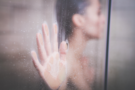 Young beautyful woman under shower in bathroom.の写真素材