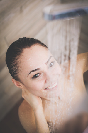 Young beautyful woman under shower in bathroom.の写真素材
