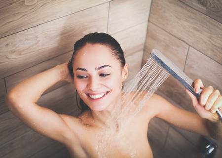 Young beautyful woman under shower in bathroom.の写真素材