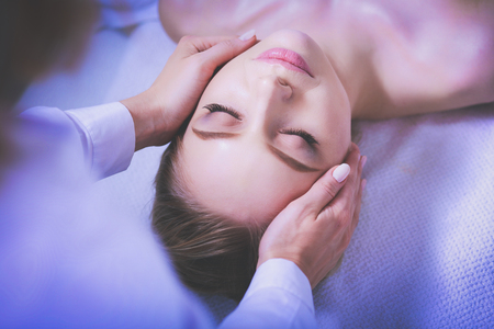 Young woman lying on a massage table,relaxing with eyes closed. Woman. Spa salonの写真素材