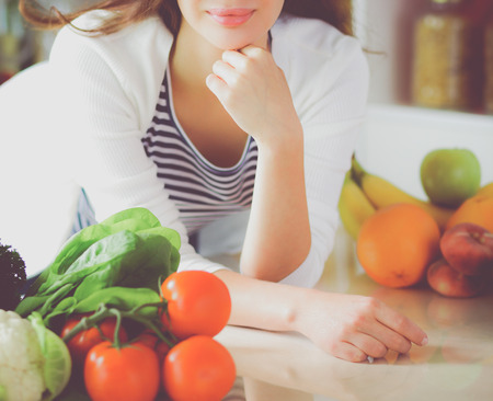 Young woman standing near desk in the kitchenの写真素材