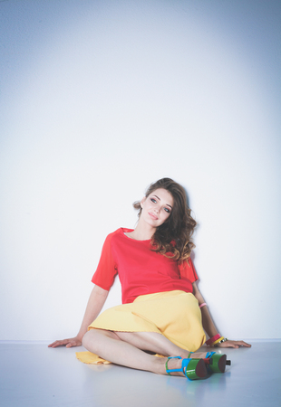 Young woman sitting on the floor, isolated in white backgroundの写真素材