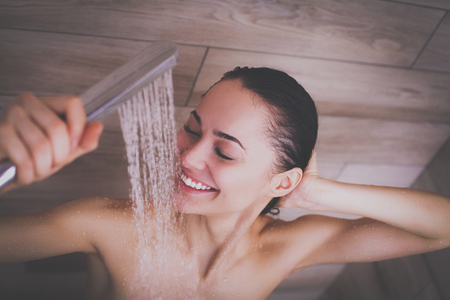 Young beautyful woman under shower in bathroom.の写真素材