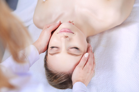 Young woman lying on a massage table,relaxing with eyes closed. Woman. Spa salonの写真素材