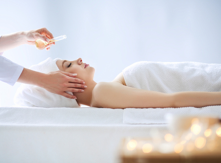 Young woman lying on a massage table,relaxing with eyes closed. Woman. Spa salonの写真素材