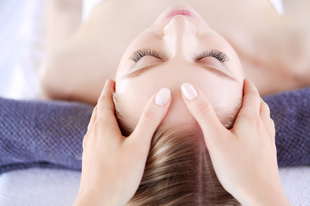 Young woman lying on a massage table,relaxing with eyes closed. Woman. Spa salonの写真素材