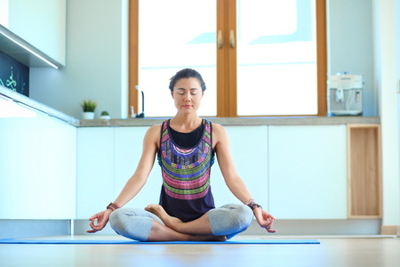 Young woman doing yoga at home in the lotus position. Yoga. Woman. Lifestyleの写真素材