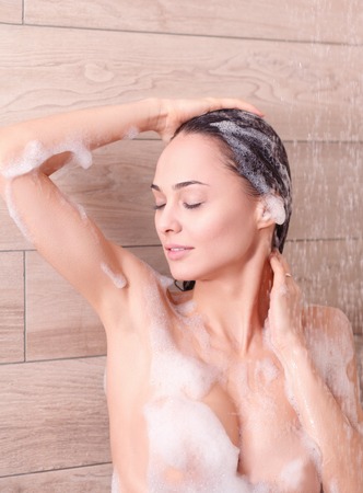 Young beautyful woman under shower in bathroom.の写真素材