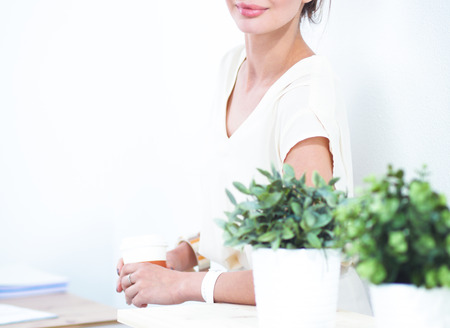 Attractive young businesswoman standing near desk in the office.の写真素材