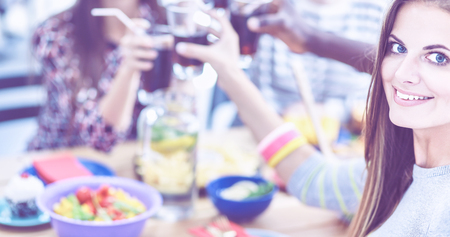 Group of people having dinner together while sitting at wooden tableの写真素材